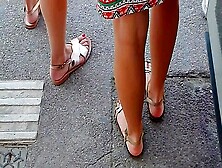 Beautiful Legs And Feet In Sandals Of Two Attractive Young Women