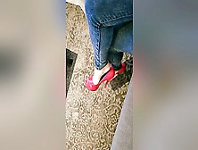 Bored Elegant Woman In Tight Blue Jeans Dangling Her Red High Heel Shoes