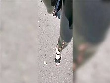 Girl Wearing Latex Leggings And High Heels In Public