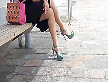 Elegant Lady Posing In Her Black Dress And High Heels In Public