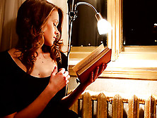 Incredibly Sexy Redhead Enjoys Reading A Book By Lamplight Next To Her Window
