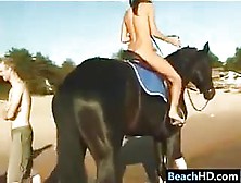 Naked Girl Riding A Horse At The Beach