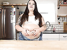 Large Dark Haired Is Pridefully Showcasing Her Thick Stomach In Front Of The Camera,  In The Kitchen