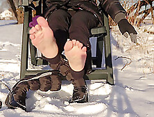 Winter Shoeplay Dangling Winter Boots Showing Soles And Wiggling Toes On Snow