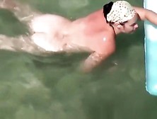 Nudist Woman Swimming In The Beach