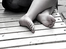 Women's Feet On A Park Bench.